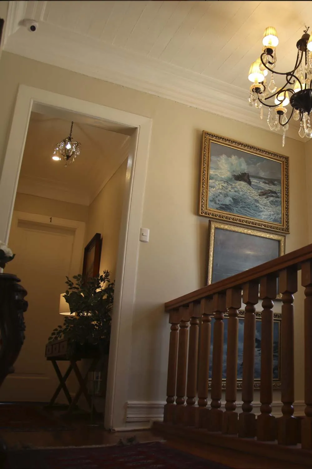 Escalera con pinturas marinas y lámpara de cristal