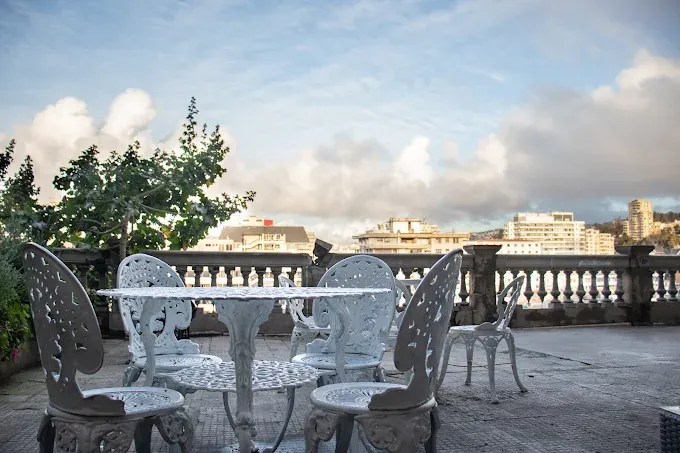 Terraza con balaustrada y mesas blancas en 180 Hotel Boutique